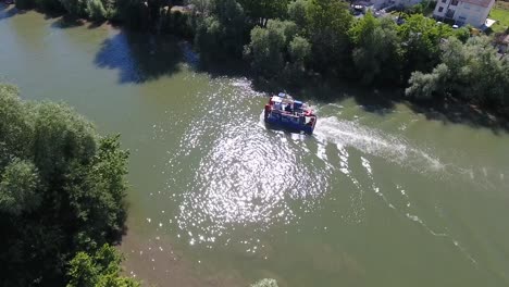 Drone-shot-following-a-tugboat-on-a-river-in-France.-Sunny-day.